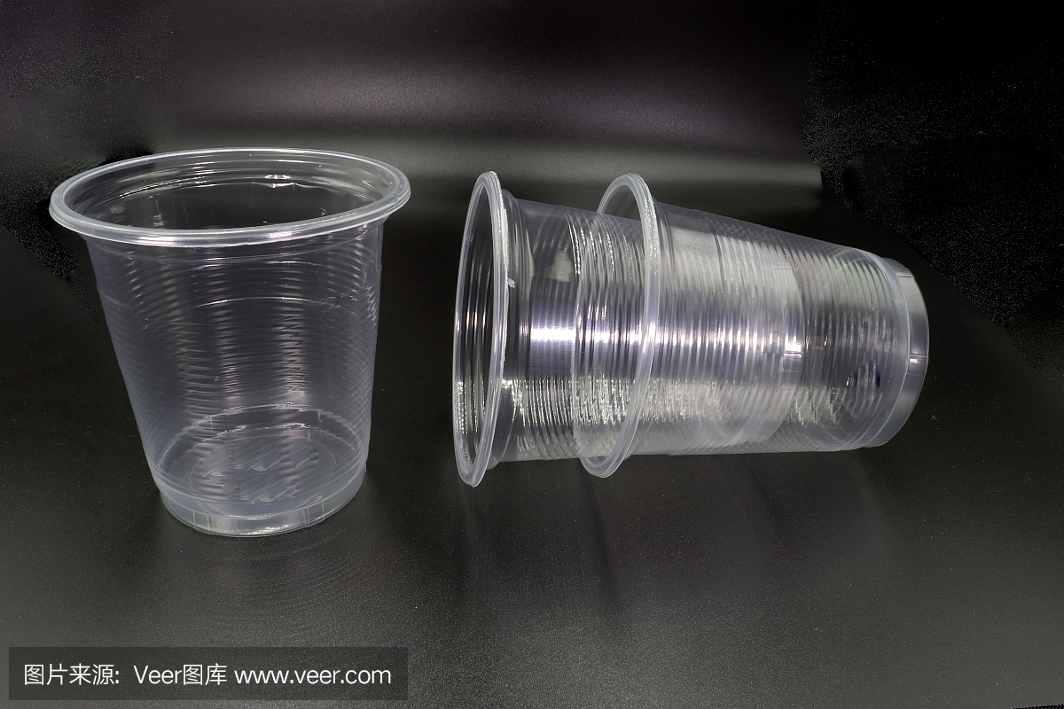 躺著和站著的塑料杯孤立在黑色的背景。高分辨率圖像庫。